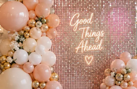 Pared shimmer con lentejuelas y globos en tonos durazno