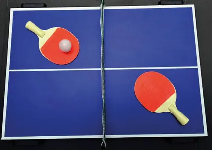 Mesa de ping pong azul con raquetas