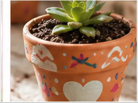 Maceta de barro decorada a mano con una planta